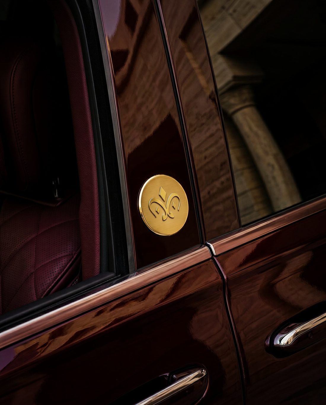 Gold emblem on a maroon car door