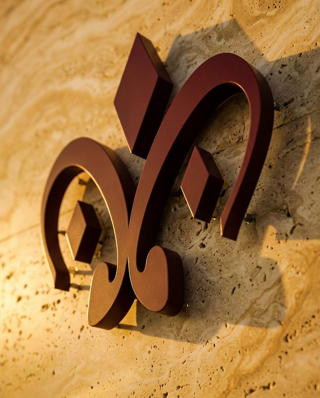 The emblem in dimensional maroon on travertine