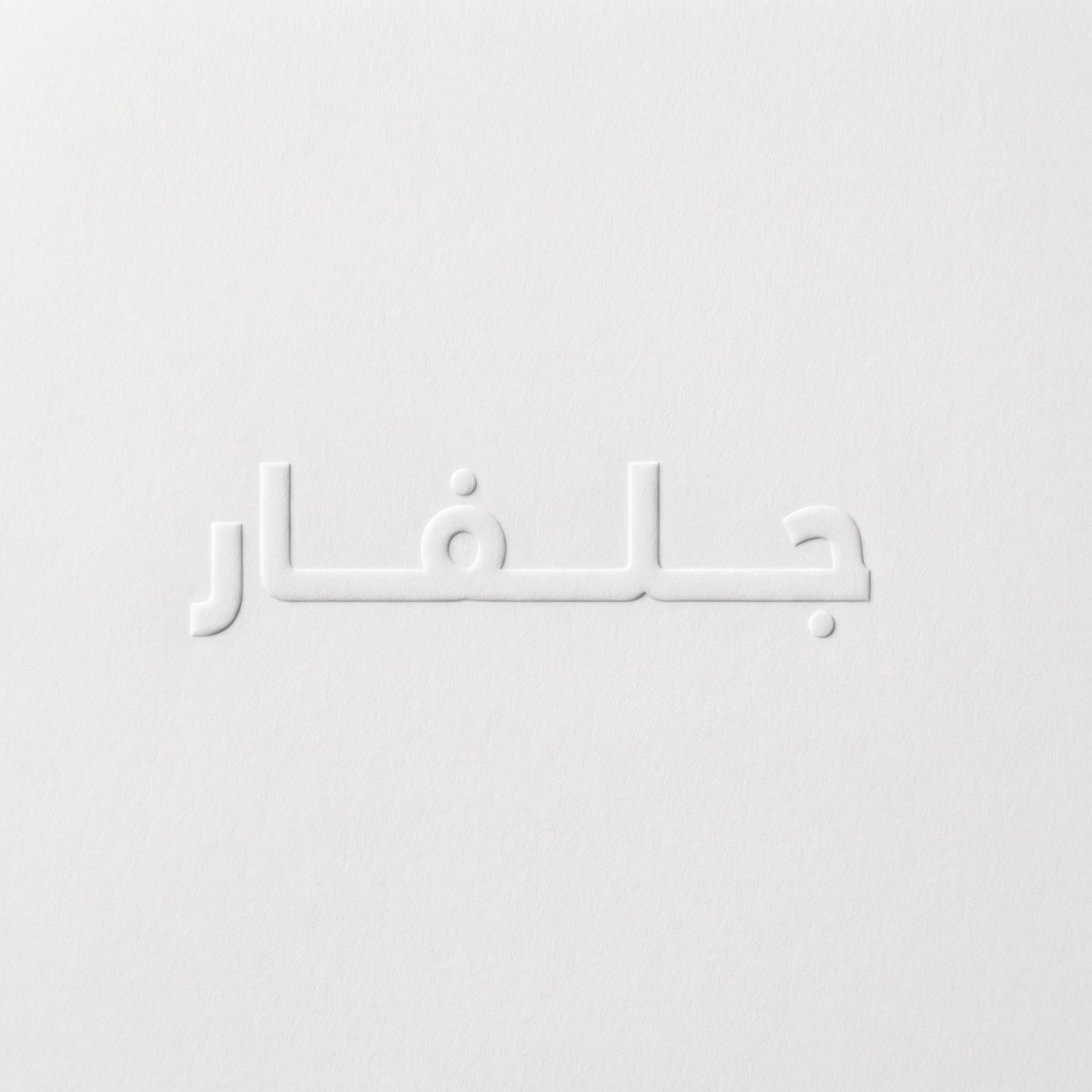 The Arabic wordmark blind-embossed into white paper